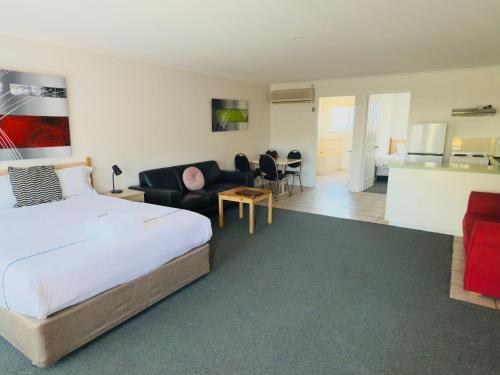 a bedroom with a bed and a living room at Beachcomber Motel & Apartments in Apollo Bay