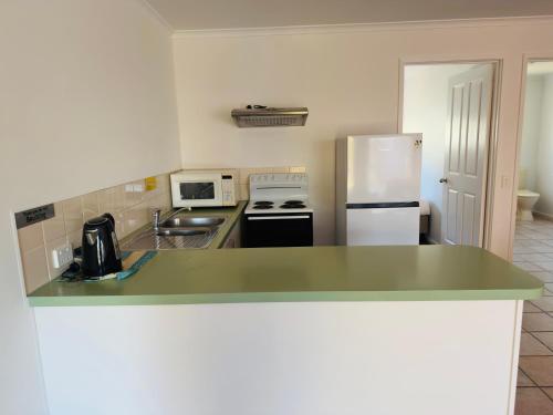 a kitchen with a green counter top and a refrigerator at Beachcomber Motel & Apartments in Apollo Bay