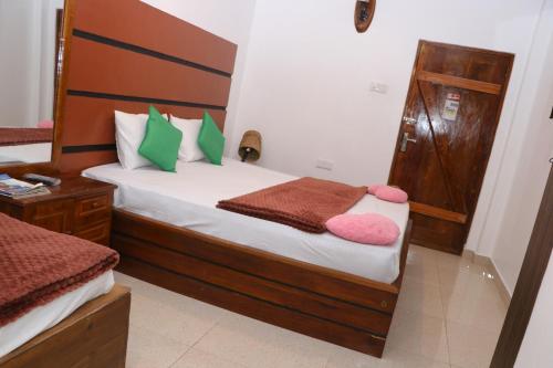 a bedroom with a bed with green and pink pillows at Mount Ash Villa Hatton in Hatton