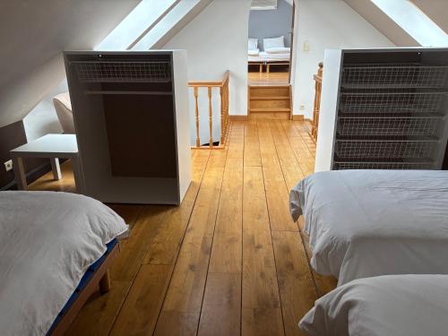 a attic room with two beds and a staircase at Le petit haut de Meuse in Profondeville