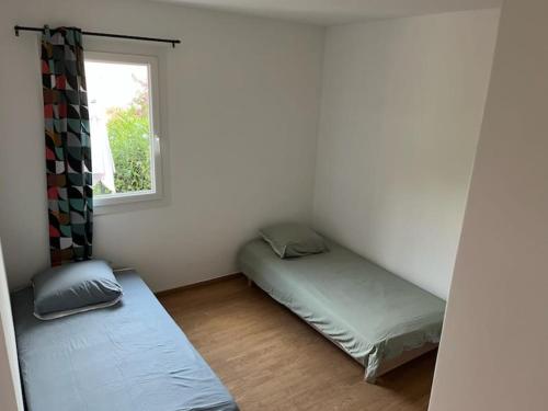 une chambre avec deux lits et une fenêtre dans l'établissement Hot Rabha, à La Croix-Valmer