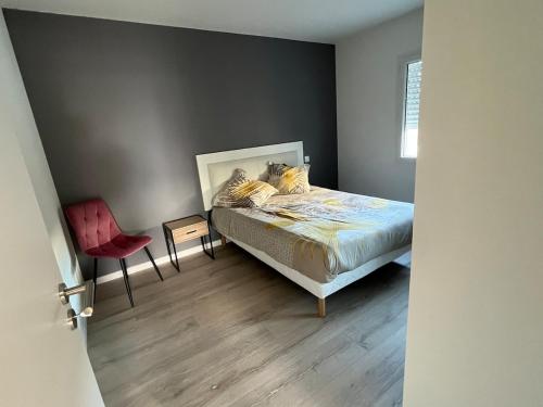 une chambre avec un lit et une chaise rouge dans l'établissement Villa avec piscine et SPA, à Saint-Gilles-Croix-de-Vie