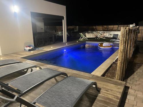 - une piscine dans une pièce entourée de chaises dans l'établissement Villa avec piscine et SPA, à Saint-Gilles-Croix-de-Vie