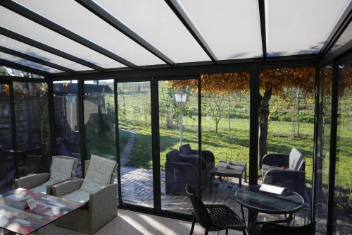 a conservatory with glass doors and a table and chairs at Hotel Garni Alte Post in Schallbach
