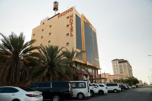 a building with cars parked in a parking lot at Ekono Hotel in Jeddah