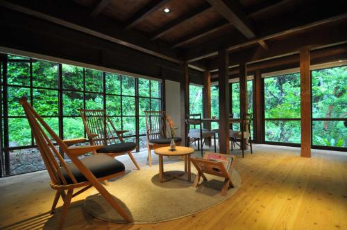 a living room with chairs and a table and windows at 五島列島おぢか島 古民家ステイ Ojika Island Kominka Stay in Ojika