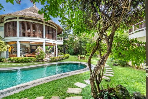 a villa with a swimming pool and a house at The Village of Angels in Manggis