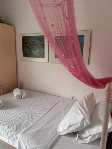 a bedroom with a bed with a pink canopy at Villa Georgia Poseidi in Kalandra