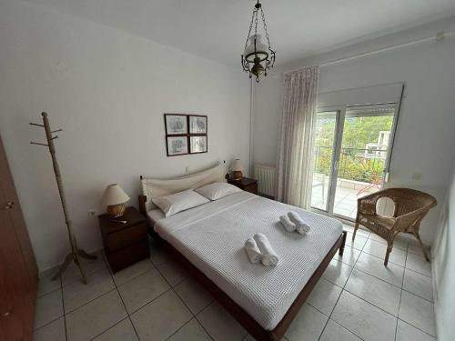 a bedroom with a bed with two towels on it at Villa Georgia Poseidi in Kalandra
