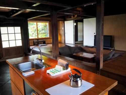 a kitchen with a sink and a living room at 五島列島おぢか島 古民家ステイ Ojika Island Kominka Stay in Ojika