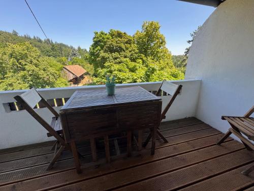 une table et des chaises en bois sur un balcon arboré dans l'établissement Gîte au Manoir des Sens - Escapade insolite aux parfums et couleurs d Asie, à Bergheim