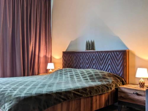 a bedroom with a large bed with two lamps and curtains at Didveli Gallery B 109 in Bakuriani