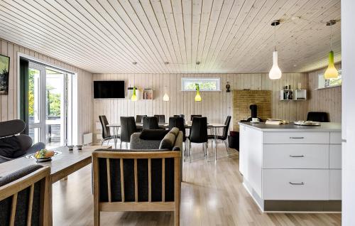 a kitchen and living room with a table and chairs at Awesome Home In Løgstør With Wifi in Løgsted