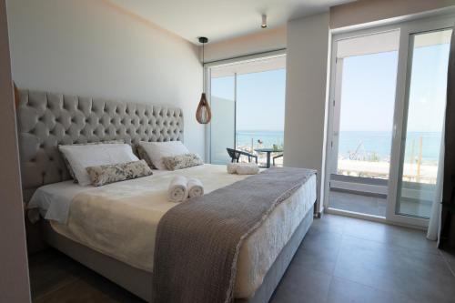 a bedroom with a large bed with a view of the ocean at Panorama Seaside in Mastichari