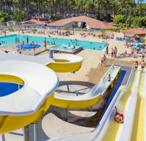 a large swimming pool with people at a water park at Mobil-home plage des casernes in Seignosse