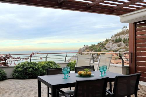 a table on a balcony with a view of the ocean at Portopiccolo Apartments in Sistiana