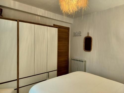 a bedroom with a bed and a closet and a chandelier at La Casita de la bahía in Pontejos