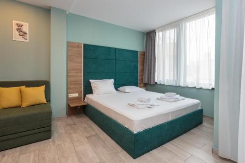 a bedroom with a large bed and a couch at All-inclusive Holiday Apartments in Tarsis Hotel & Aquapark in Sunny Beach