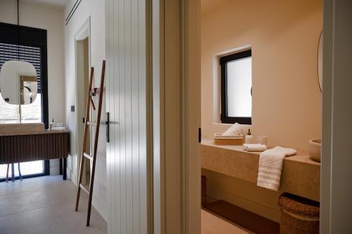 a bathroom with a sink and a mirror at White Arch Villa in Ayia Evfimia