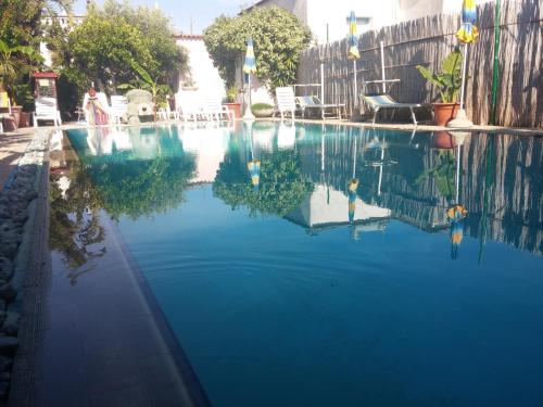 a pool of blue water with chairs and a fence at Hotel Casa Nicola in Ischia