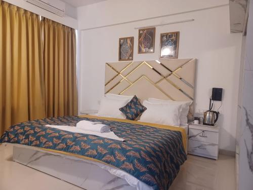 ein Hotelzimmer mit einem Bett, auf dem ein Hut liegt in der Unterkunft EXPAT STYLED 2 BHK IN BANER BALEWADI , Pune in Pune