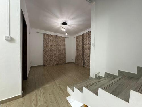an empty living room with stairs and curtains at Residence Haulkory in Belle Vue