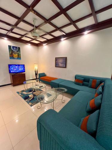 a living room with blue couches and a tv at LUXURY family cottage in Islamabad