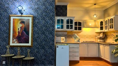 a kitchen with a painting of a woman on the wall at LUXURY family cottage in Islamabad
