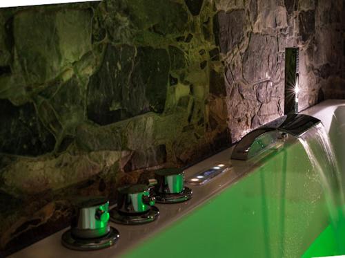 a bathroom with a green tub with a water fountain at Il Salento di Fioravante in Specchia Gallone