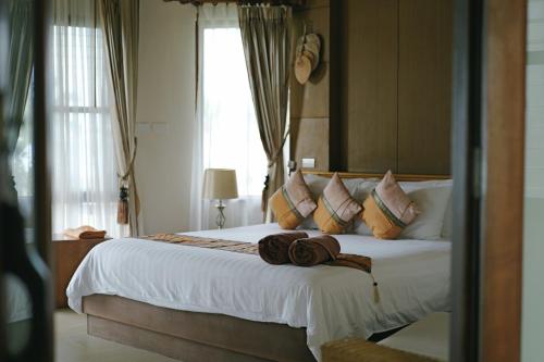 a bedroom with a bed with two hats on it at Better View Koh Yao Yai in Ko Yao Yai