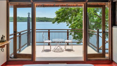a room with a balcony with a view of the water at SaffronStays Suvarna Sangam, Udupi in Udupi