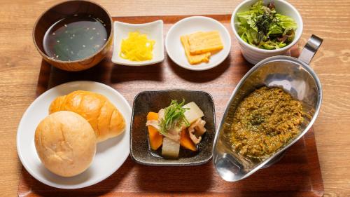 a table topped with plates of food and bowls of food at APA Hotel Nambaminami Daikokucho Ekimae in Osaka