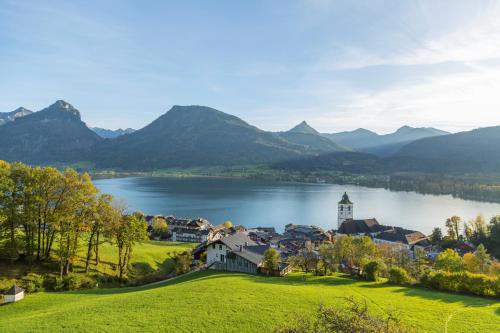 a village on the shore of a lake with a church at Altroiterhof in St. Wolfgang