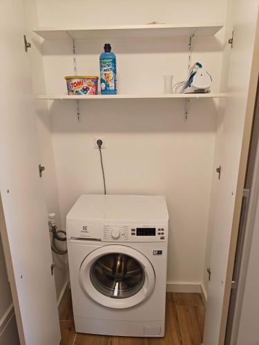 a laundry room with a washing machine and shelves at Anna's Residence 2 in Budapest
