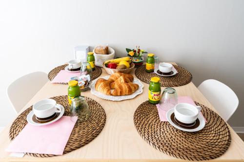 a table with a breakfast of croissants bread and drinks at BnB Paoli in Rovereto