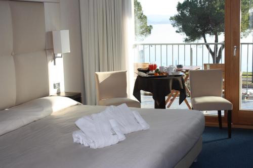 a hotel room with a bed and a table and chairs at Cocca Hotel Royal Thai Spa in Sarnico