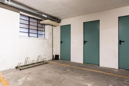 an empty room with three doors and a window at BnB Paoli in Rovereto