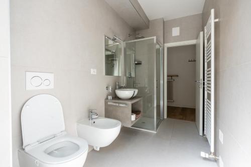 a white bathroom with a toilet and a sink at BnB Paoli in Rovereto