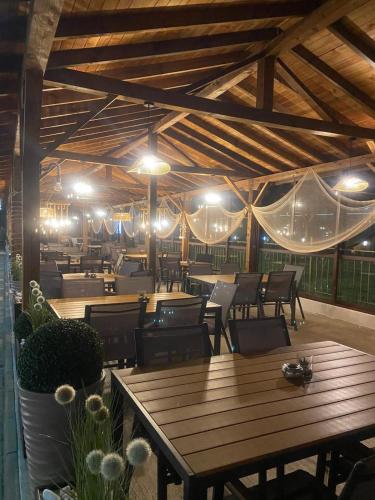 a restaurant with wooden tables and chairs and lights at Aparthotel Hotel Prestige City II in Primorsko