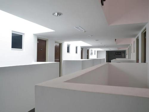 a white room with a white counter in a building at Aster+ Hotel Bukit Jalil in Kuala Lumpur