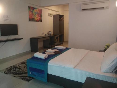 a bedroom with a large bed and a television at Aster+ Hotel Bukit Jalil in Kuala Lumpur