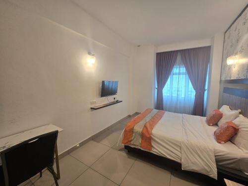 a bedroom with a bed and a tv on the wall at Aster+ Hotel Bukit Jalil in Kuala Lumpur