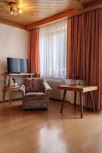 a living room with a chair and a table at Pension Schlossberg in Mittersill