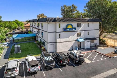 a building with cars parked in a parking lot at Days Inn by Wyndham Woodland in Woodland