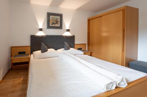 a bedroom with a large white bed with white pillows at Apart Sunnbichl in Nauders
