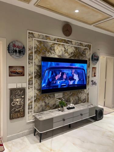 a living room with a tv on a stone wall at LUXURY family cottage in Islamabad