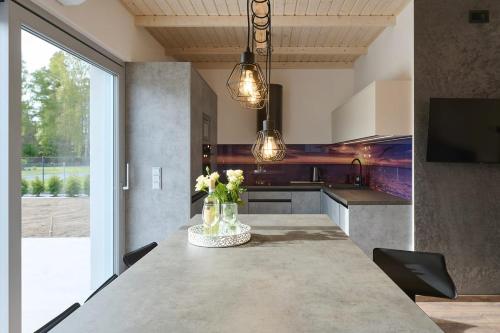 a kitchen with a table with vases of flowers on it at Klangor in Kopalino