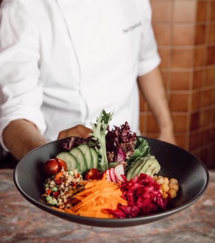 a person holding a plate of food on a table at Grand Hyatt Istanbul in Istanbul