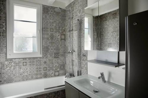 une salle de bain avec un lavabo et une fenêtre dans l'établissement Maison 11p au calme avec clim et piscine, à Lacanau