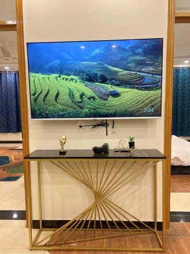 a large tv on a wall with a television on it at LUXURY family cottage in Islamabad